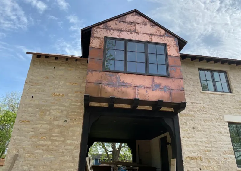 Copper metal panel facade on a stone building for Skylight Installation in Villas